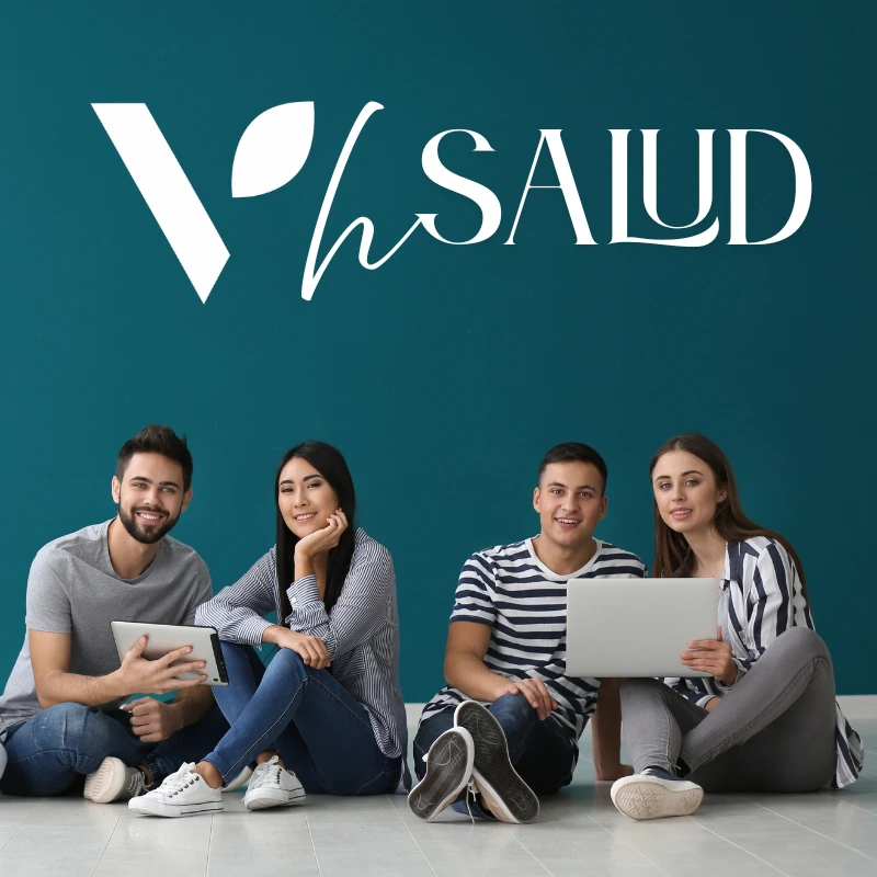 Grupo de jóvenes afiliados a VitalHealth Salud reunidos con dispositivos electrónicos, representando la comunidad y apoyo del equipo VHSalud.